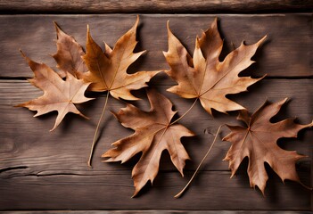 Obraz premium Crisp brown leaves over a rustic wooden background for an autumn feel, AI Generated