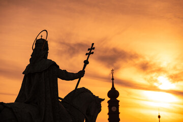 Saint Stephen and its cross silhouette against sunset sky. Concept religious photo with Szent Istvan in Hungarian, the most important saint of Hungary.