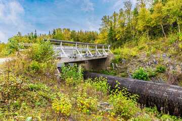 Fototapeta premium A view of a bridge over a leaking wooden-stave water pipe above Corner Brook in Newfoundland, Canada in the fall