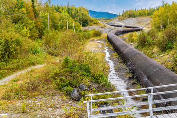 A view of a wooden-stave water pipe snaking along above Corner Brook in Newfoundland, Canada in the...