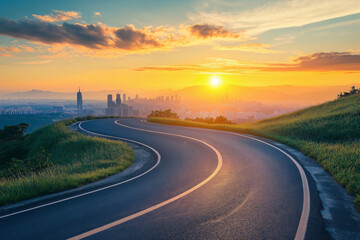 Obraz premium Winding road leading through green fields towards a city skyline bathed in the golden light of sunset