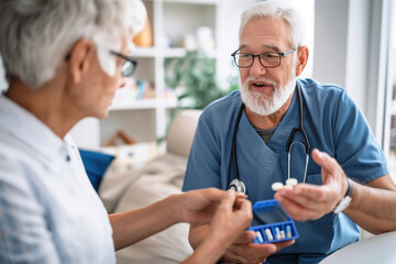 A caregiver organizing pills into a weekly pillbox, while explaining dosage to a senior