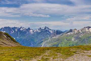 Val Veny scenic landscape in Courmayeur valley, Italy on Tour du Mont Blanc hiking route. Alps beautiful landscape, scenic view of the alpine peaks, green fields and meadow with flowers and blue sky