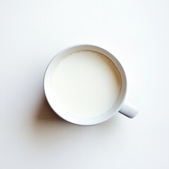 Cup of warm frothed milk on minimal white background.