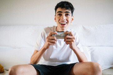 A teenager plays video games at home.