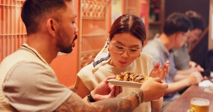 Night, people and eating in Japan with street food, traditional snack or yakitori to share. Happy couple, travel or chicken skewer at Tokyo bazaar to experience culture, tourism or indigenous cuisine