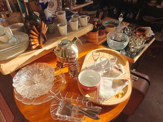 A variety of beautiful and vintage second-hand items displayed on shelves in a Swedish thrift...