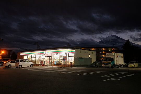 Fujiyoshida, Japan : 7-Eleven convenience store by night with Mount Fuji on the background