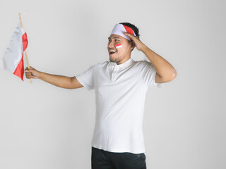 Handsome Asian man giving salute celebrate Indonesian independence day on 17 August isolated over white background