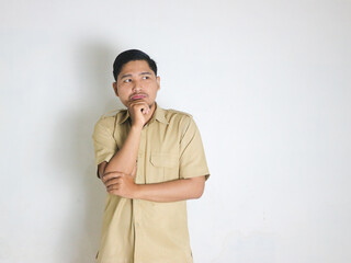 Asian male Indonesian civil servant wearing a brown uniform commonly called keki standing and...