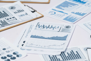 Piles of business intelligence paper or BI financial report and financial data visualization on...