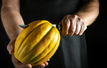A skilled individual carefully carves a bright yellow melon, showcasing precise technique and...
