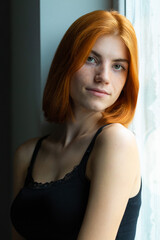 Cute red-haired girl, studio portrait on a black background.