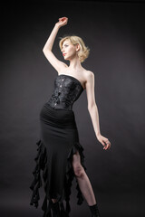 Fototapeta premium Expressive young blonde under a bob in the studio. In a black corset and dress.