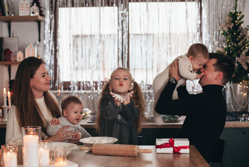 family with children in the kitchen in winter cooking