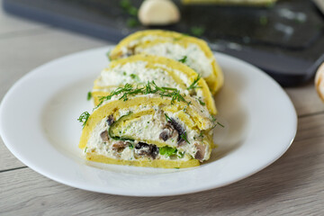 baked potato roll with cottage cheese filling with garlic and mushrooms, on a light wooden table