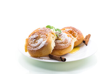 Baked goods. Sweet buns with cottage cheese filling and honey in a plate isolated on a white background