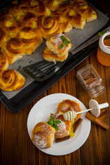 Pastries. Sweet buns with cottage cheese filling and honey in a plate on a wooden table