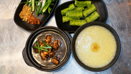 Eminent frog porridge or Singapore frog porridge and green onion in clay pot. Singapore braised frog and spring onion. Spicy frog porridge. 