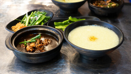 Eminent frog porridge or Singapore frog porridge and green onion in clay pot. Singapore braised frog and spring onion. Spicy frog porridge. 