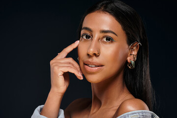 African American woman with brunette hair highlights jewellery in a studio setting.