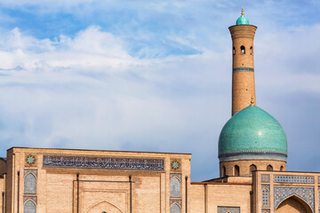 View of the Hazrati Imam Mosque in Tashkent, featuring its iconic turquoise dome and tall brick...