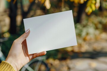 A blank white postcard is held by a hand