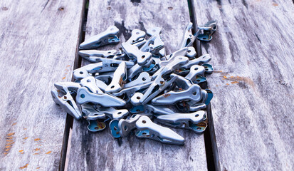 Pile of old clothespins from aluminum. Made of genuine stainless steel on grey, brown table wooden. 360 swivel swivel for drying socks and underwear. Thick, sun-resistant, rain, not rusty.