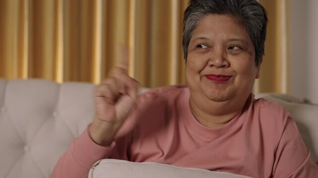 Footage medium shot, captures face of asian senior woman with short hair with hand on ear for listening voice and Show signs of prohibition with facial expressions and gestures.
