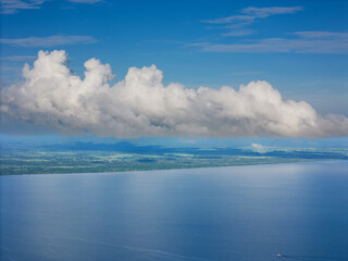 Big white cloud over shore land