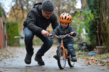 Father teaches his toddler son to ride a bicycle