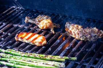Pork, chicken and green asparagus on a grill grill is grilled