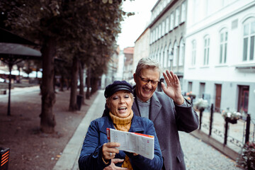 Senior mature couple exploring city with map