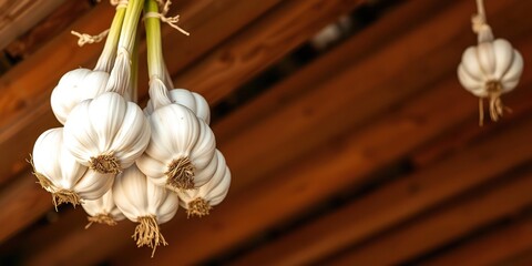 Garlic bulbs dangle from a wooden rafters, home decor, earthy, kitchen