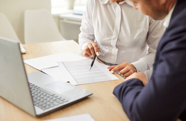 Business people in an office working together on papers, engaging in accounting or audit tasks....