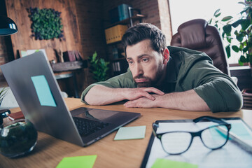 Photo of handsome young guy tired manager work netbook dressed green shirt comfortable startup...