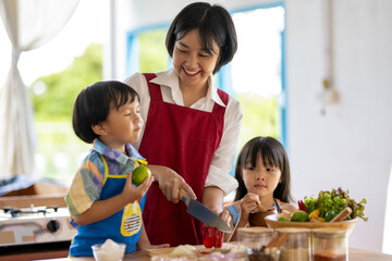 Naklejka premium Happy family cooking together in a bright kitchen