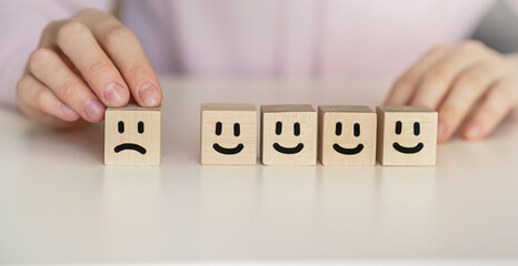 Wooden Level of mental health assessment max positive. cubes blocks with happy and sad face smile...
