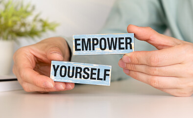 Empower yourself symbol. Wooden blocks with words Empower Yourself on white background. Business woman hand.