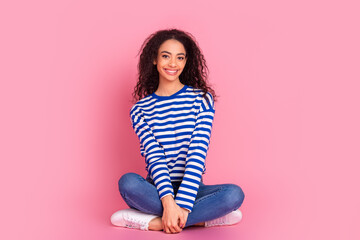 Full size photo of pretty young girl sit floor empty space isolated on pink color background