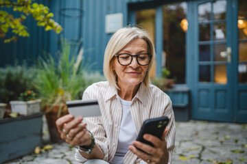 woman sit in front restaurant and shop online with credit card