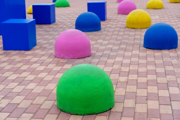 Vibrant blue, yellow, pink, and green shapes strategically placed on a patterned brick surface...