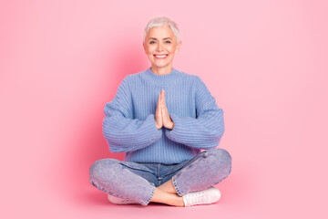 Full body photo of lovely pensioner lady sit floor meditation pray dressed blue knitwear garment...
