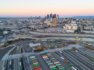 Fototapeta premium Los Angeles rail yard and downtown LA at dawn, aerial view , clear sky.