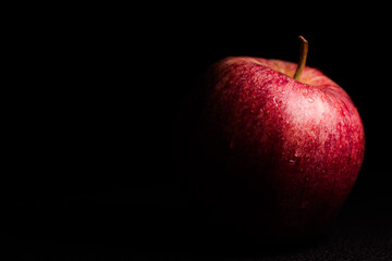 Red magic apple in the dark, black background. Czerwone jabłko na czarnym tle.