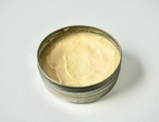 Deodorant cream skin care product inside round metal tin jar container isolated on horizontal ratio background.