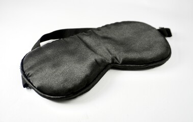 One black colored night sleep blind fold object photography isolated on horizontal white background.