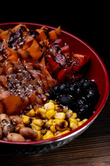 Salad with avocado, corn, olives, beans carrots, tomato,  chickpeas, sauce.