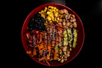Salad with avocado, corn, olives, beans carrots, tomato,  chickpeas, sauce.