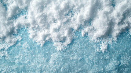 Obraz premium This image showcases a close-up of snow texture atop an icy blue surface, creating a serene winter landscape with soft, fluffy snowflakes and subtle lighting.